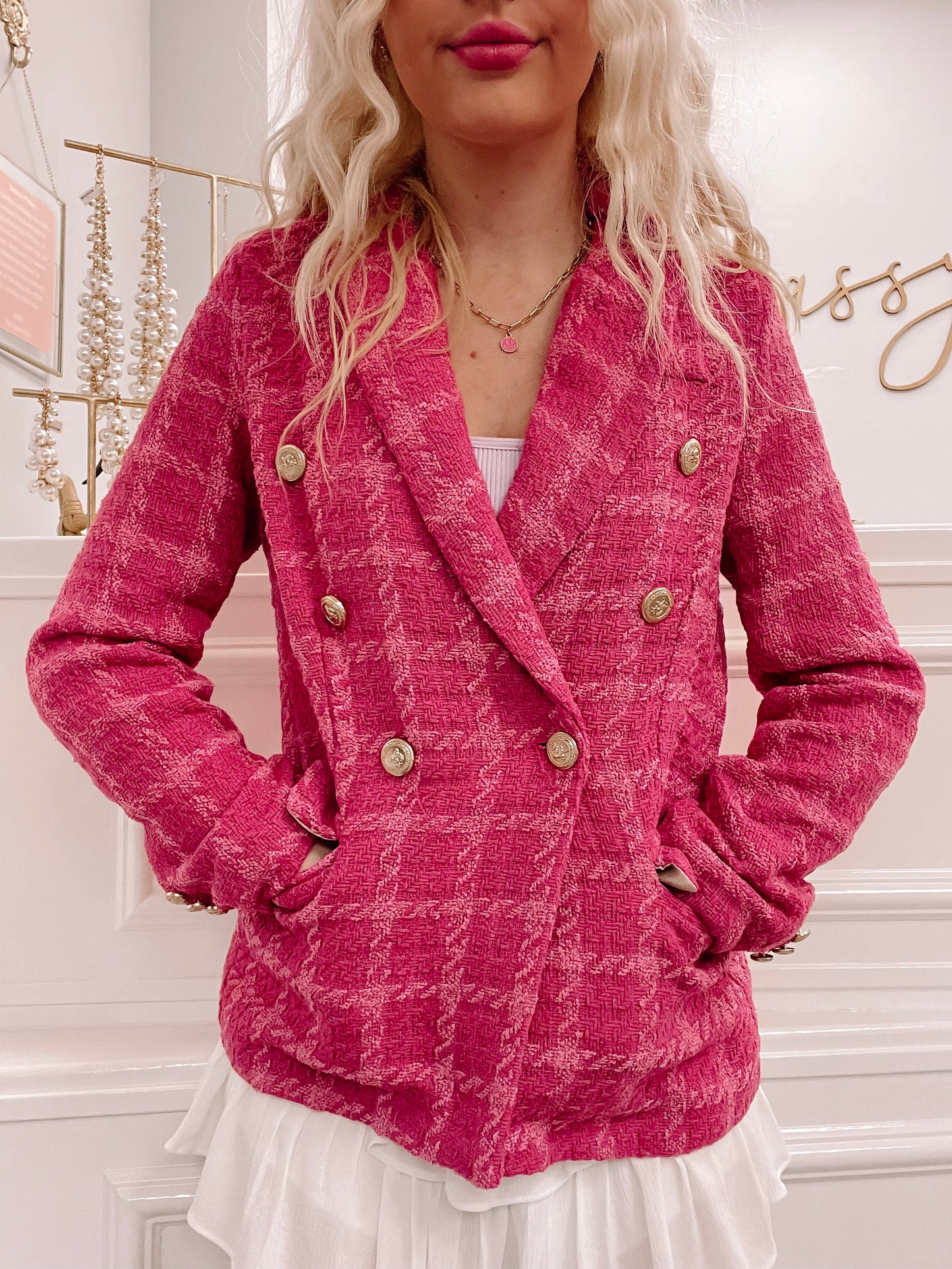 Hot pink tweed jacket with gold buttons, shown on a model.
