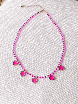 Pink and white beaded necklace with pink heart charms.