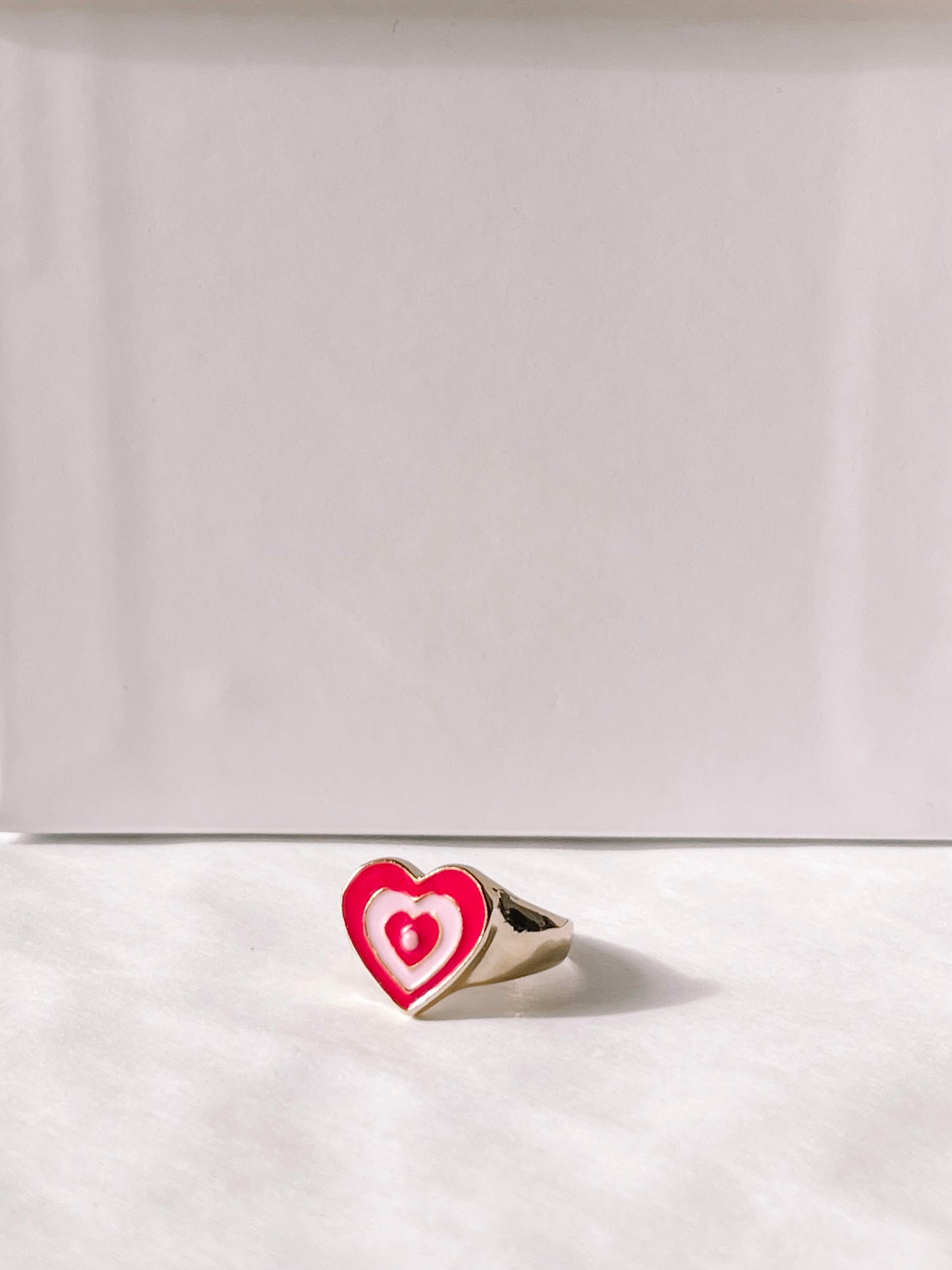 Gold Love Me ring with pink & white enamel heart.