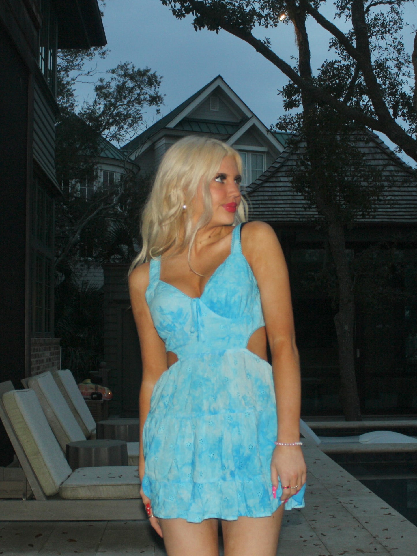 Light blue eyelet mini dress with cutouts, worn outdoors near a pool.