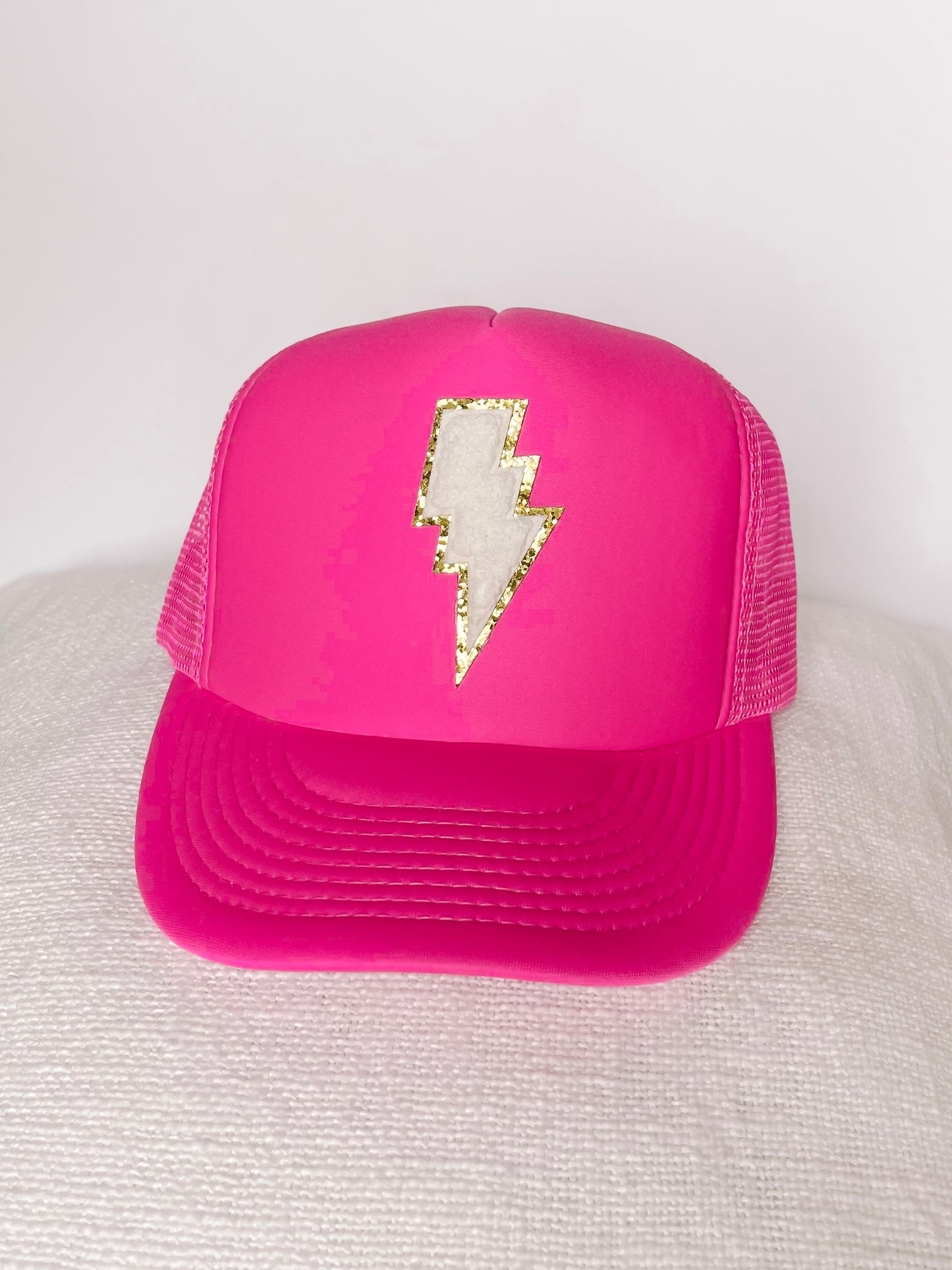 Pink Lightning trucker hat with gold glitter lightning bolt detail.