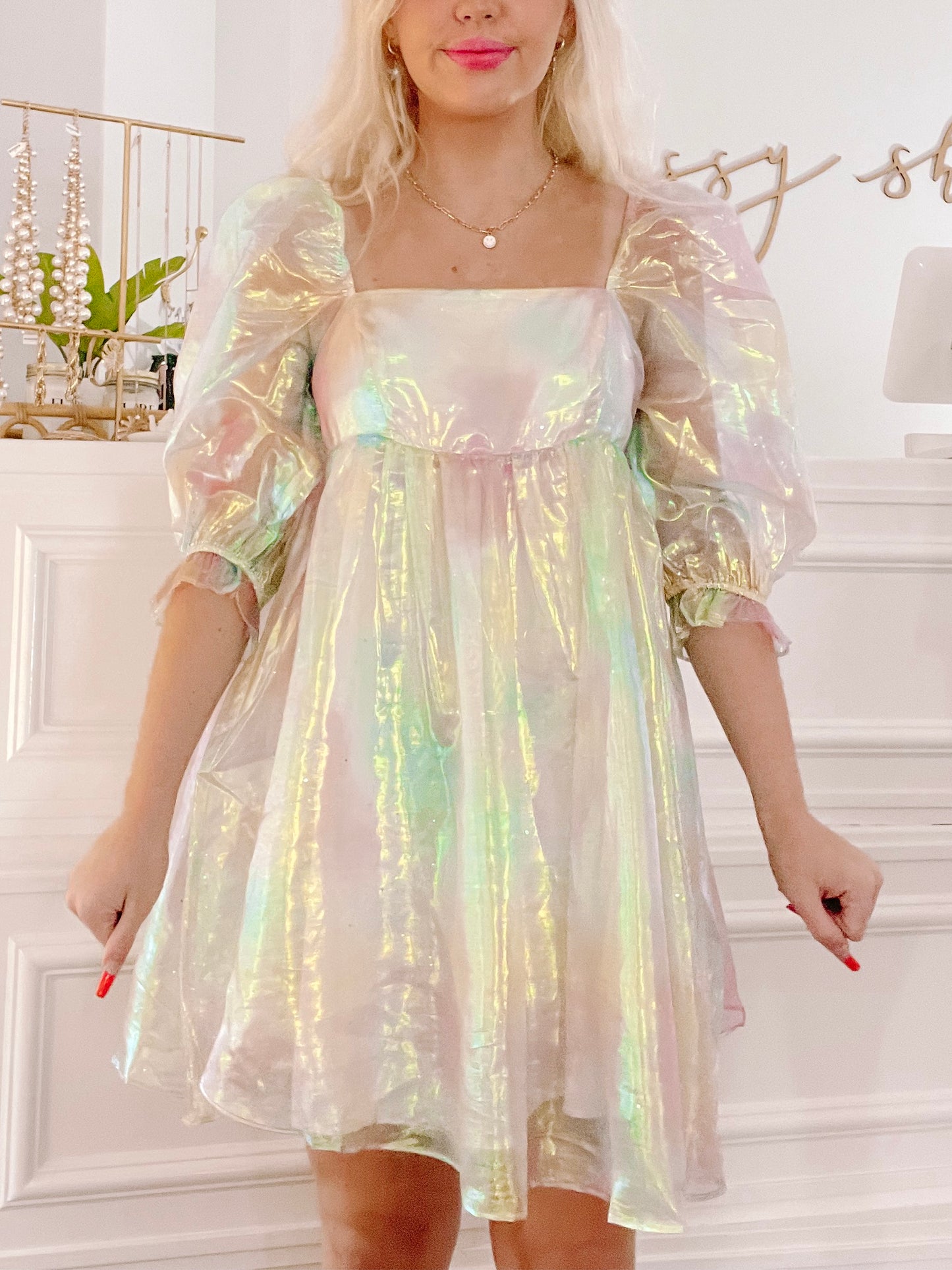 Iridescent mini dress with puff sleeves, shown on a model against a white background.