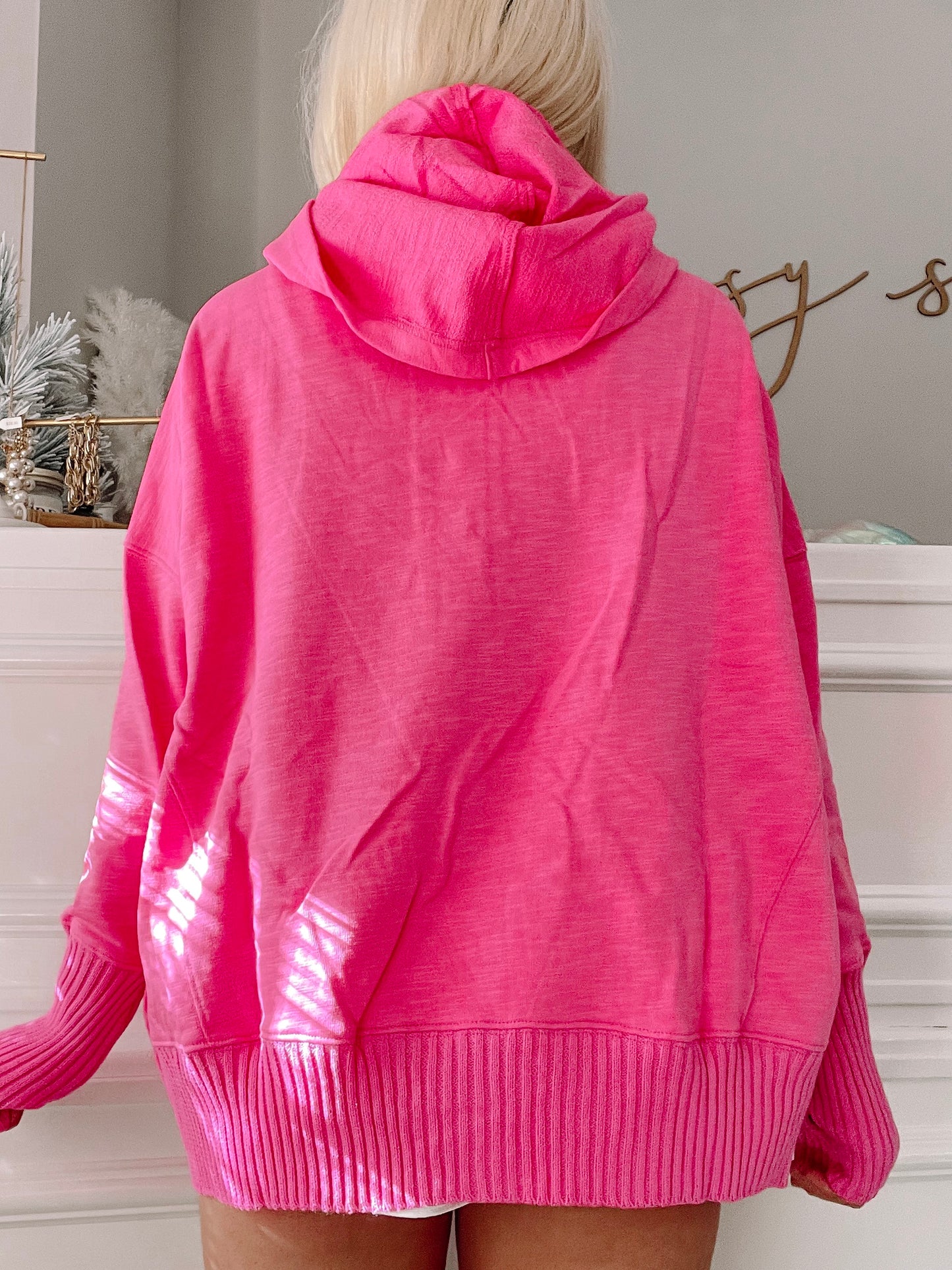 Hot pink pullover sweater with ribbed cuffs and hem, shown from the back.