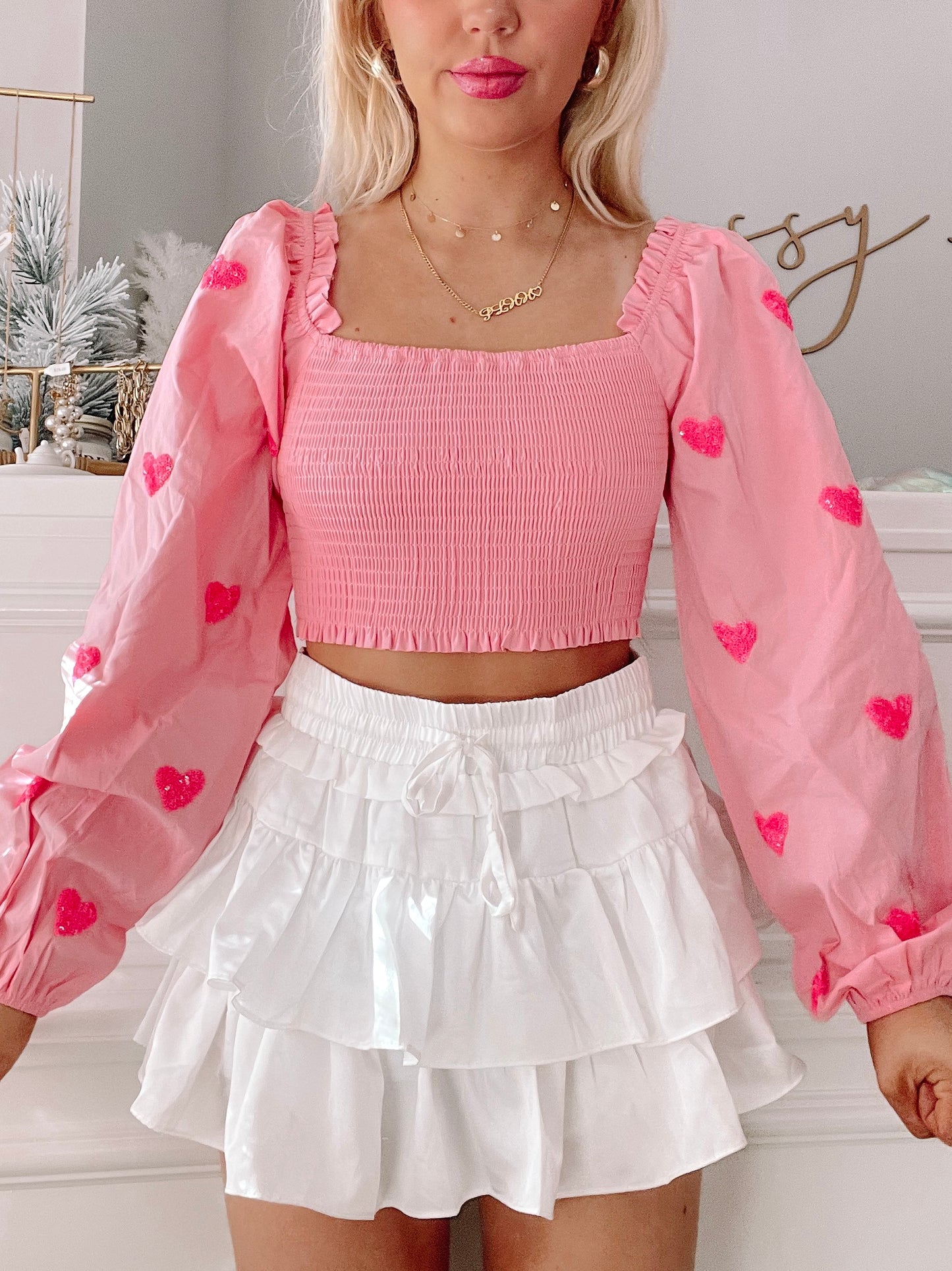 Pink smocked crop top with pink heart details; long sleeves, perfect for a romantic look.