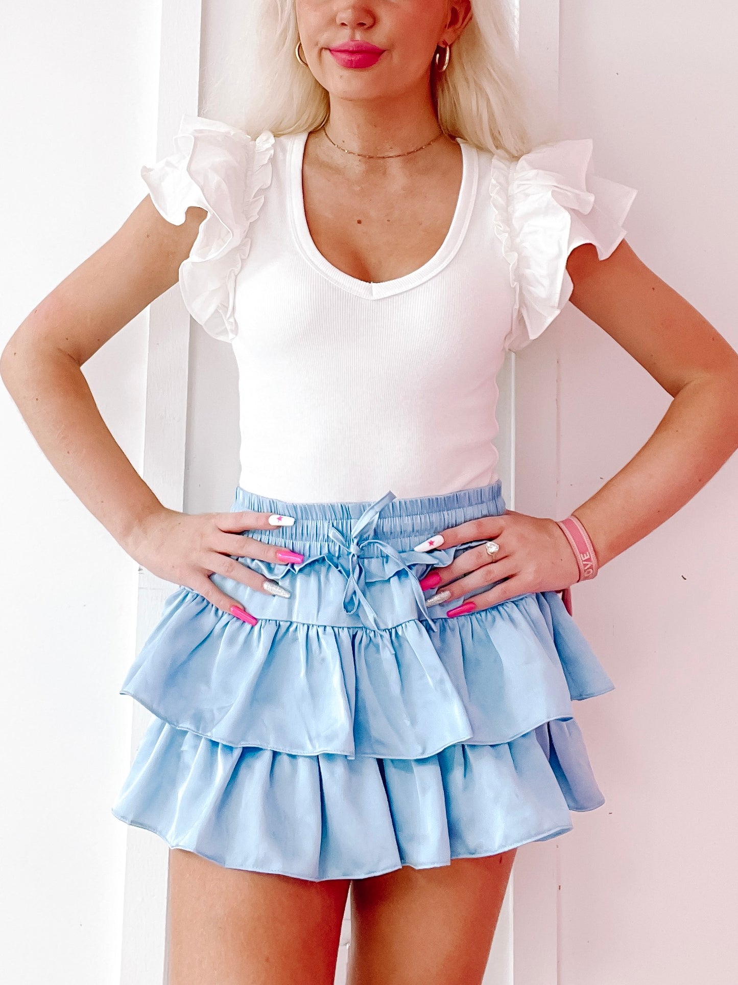Light blue ruffle mini skirt layered for a flirty look.