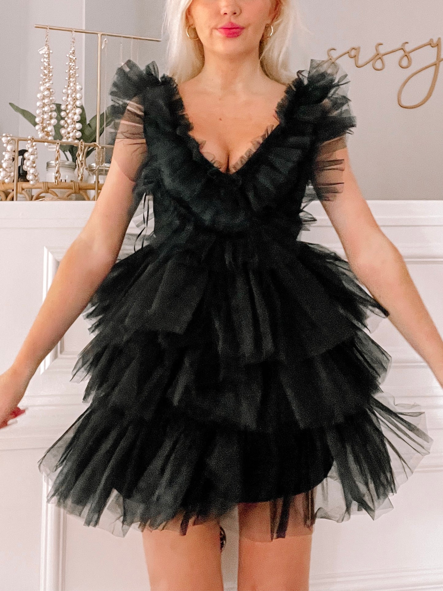 Black tulle mini dress with tiered ruffles and V-neckline.