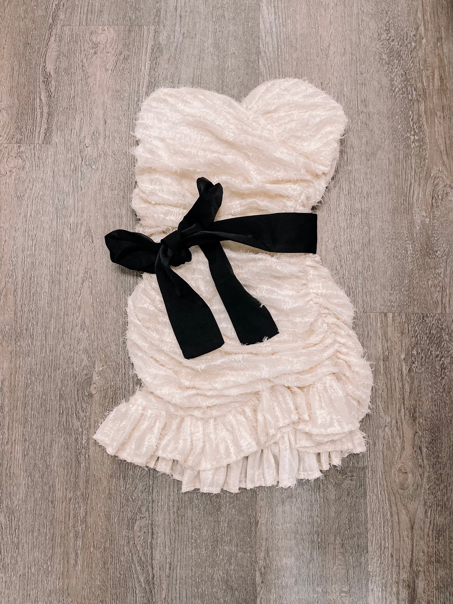 Cream ruffled Vanilla Bean dress with black ribbon belt.