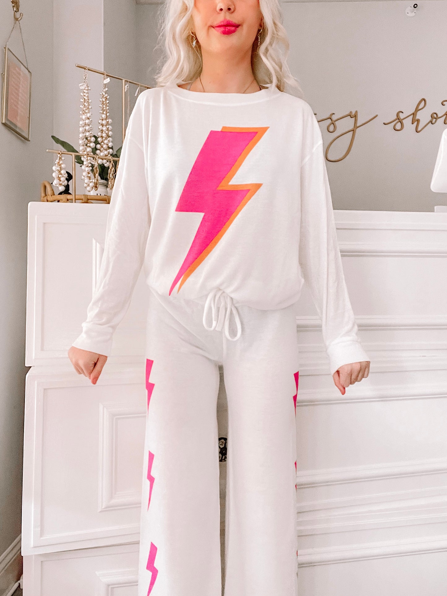 White pajama set with pink and orange lightning bolt print, shown on model.