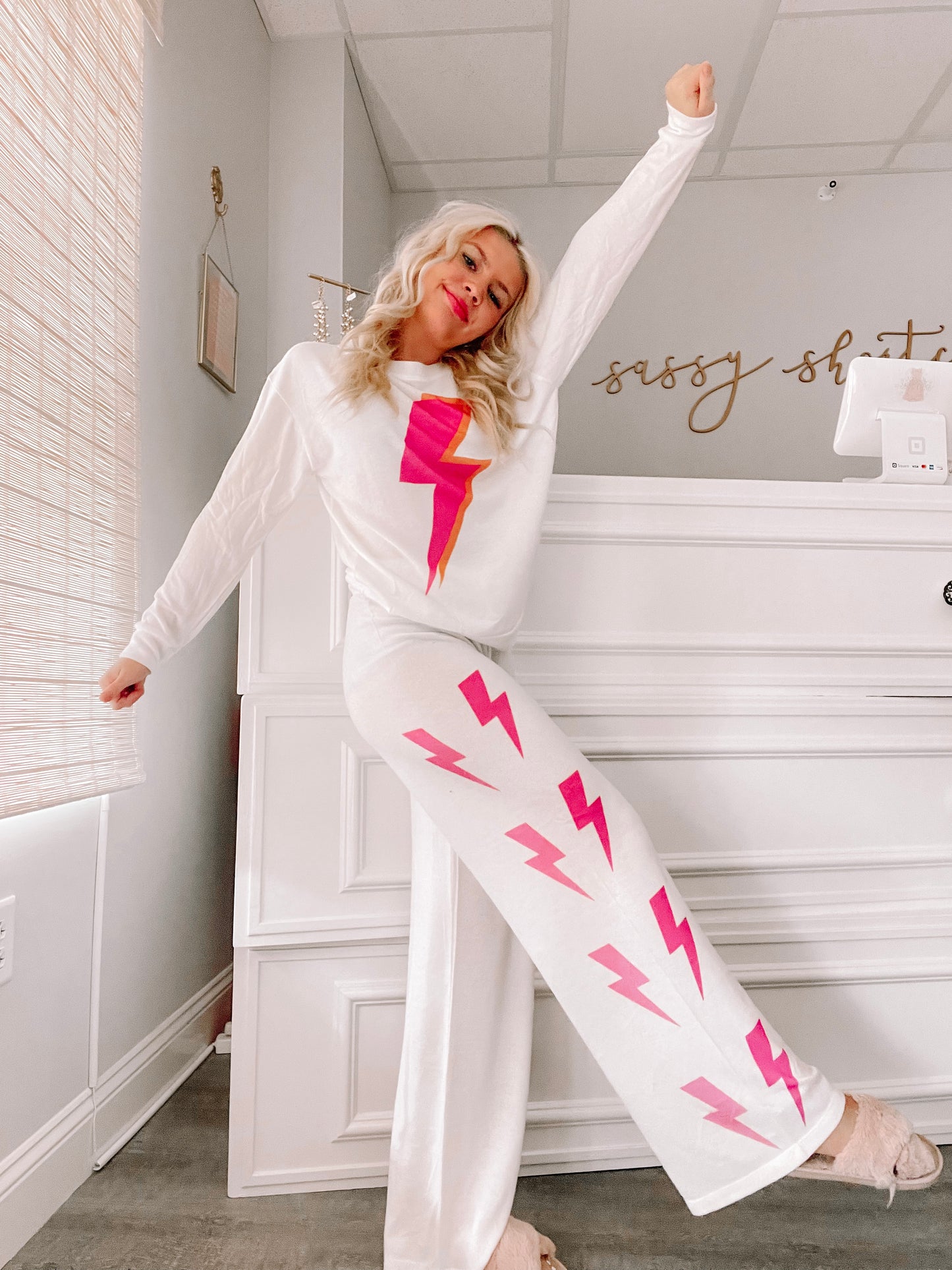 White pajama set with pink lightning bolt print, lifestyle shot.