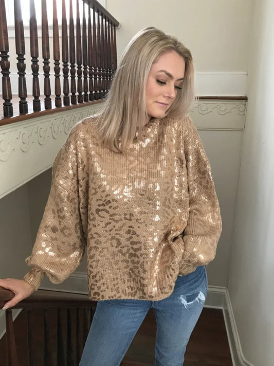 Gold metallic leopard print knit sweater; oversized fit, modeled indoors near a staircase.