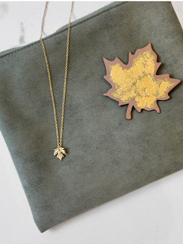 Gold Leaf Charm necklace on olive green suede