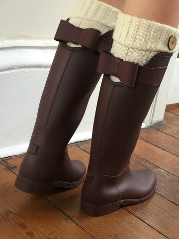 Burgundy rain boots with decorative bows and cream-colored knit leg warmers.