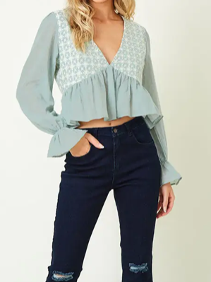 Mint green embroidered peasant top with ruffled hem, long sleeves, and V-neckline.