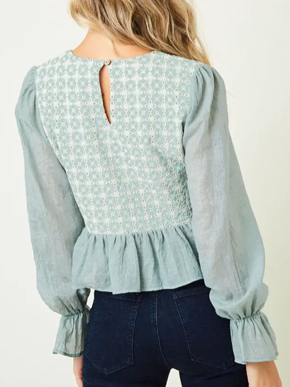 Mint green embroidered peasant top with long sleeves and a ruffled hem.