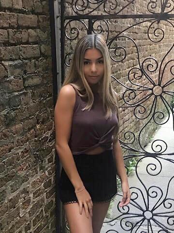 Woman modeling mauve knotted crop top and black shorts.