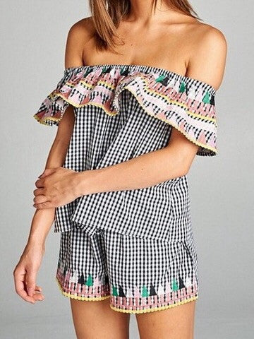 Black and white gingham off-the-shoulder top and shorts set with colorful embroidered trim.