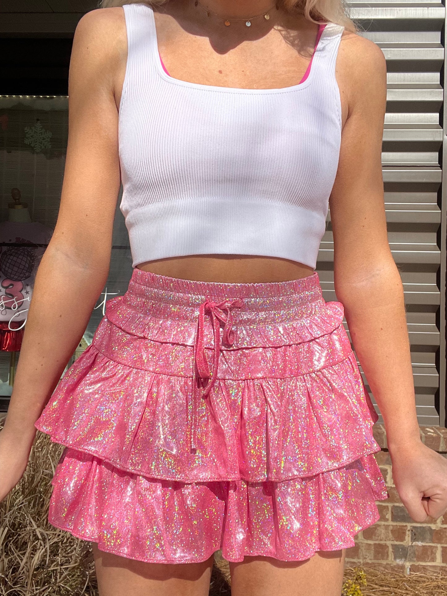 Pink sparkly mini skirt with tiered ruffles, worn outdoors.