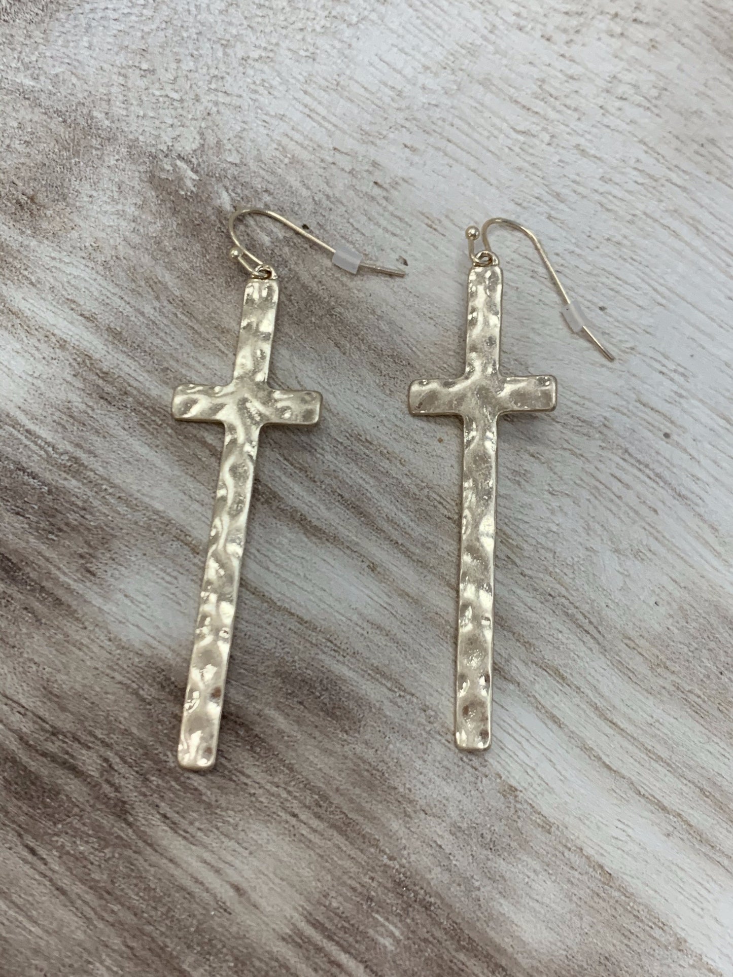 Gold hammered cross earrings with textured detail.
