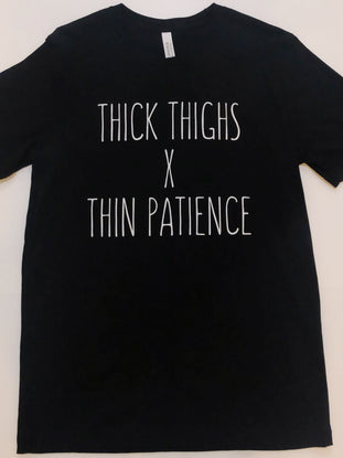 Black t-shirt featuring "Thick thighs x thin patience" in white lettering.