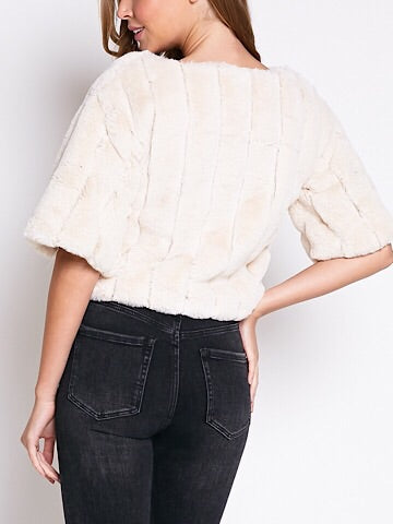Cream faux fur cropped top with short sleeves, shown from the back on a model.