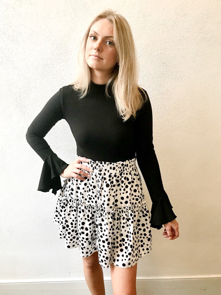 Tiered dalmatian-print mini skirt styled with a black long-sleeve top.