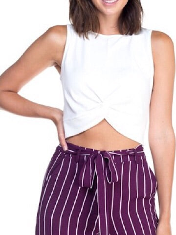 White knotted crop top on model, styled with striped pants.
