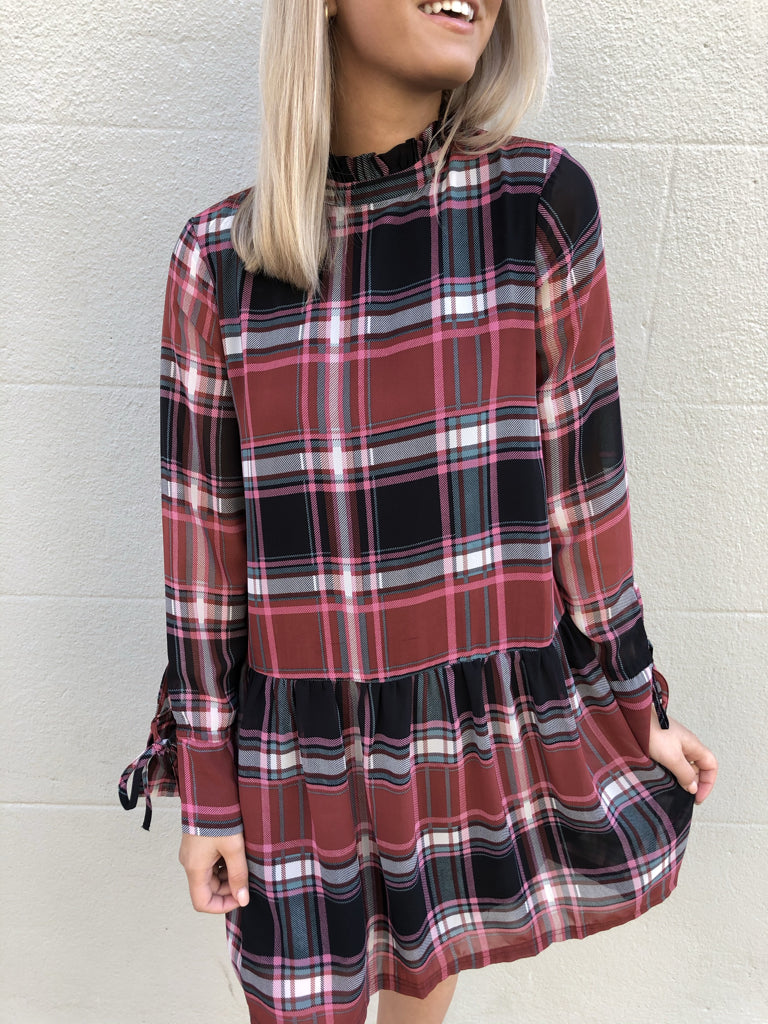 Red, black, and pink plaid long-sleeve mini dress with tie cuffs.