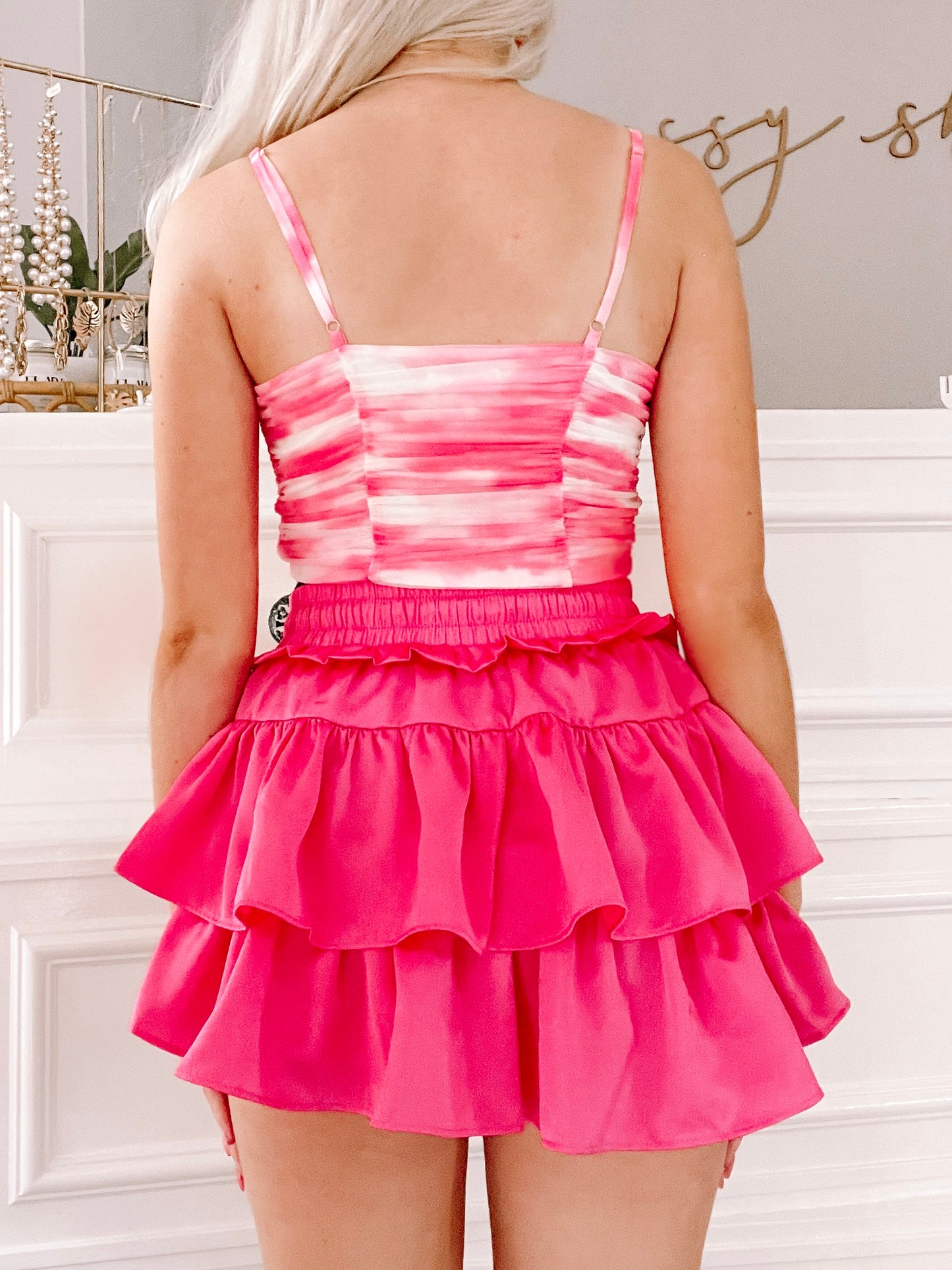 Hot pink tiered mini skirt and pink and white tie-dye cami, rear view.