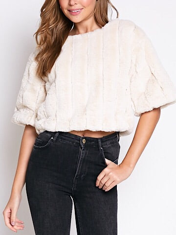 Cream faux fur cropped top with short sleeves, modeled with dark wash jeans.