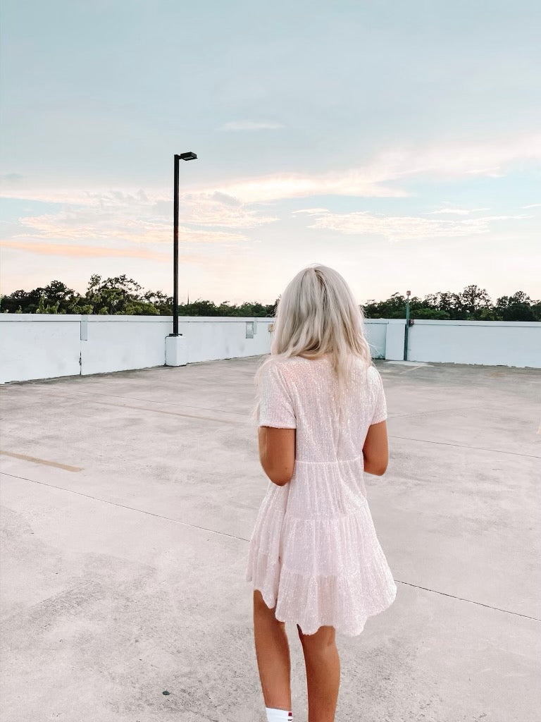 Pink tiered mini dress on a rooftop at sunset.