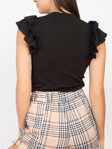 Black ribbed top with ruffled sleeves, shown paired with plaid shorts.