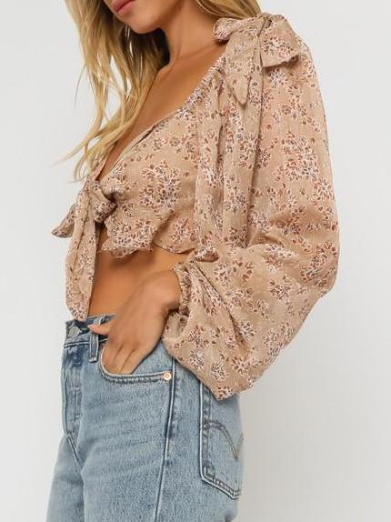 Beige floral print tie-front blouse with long sleeves, shown on model.