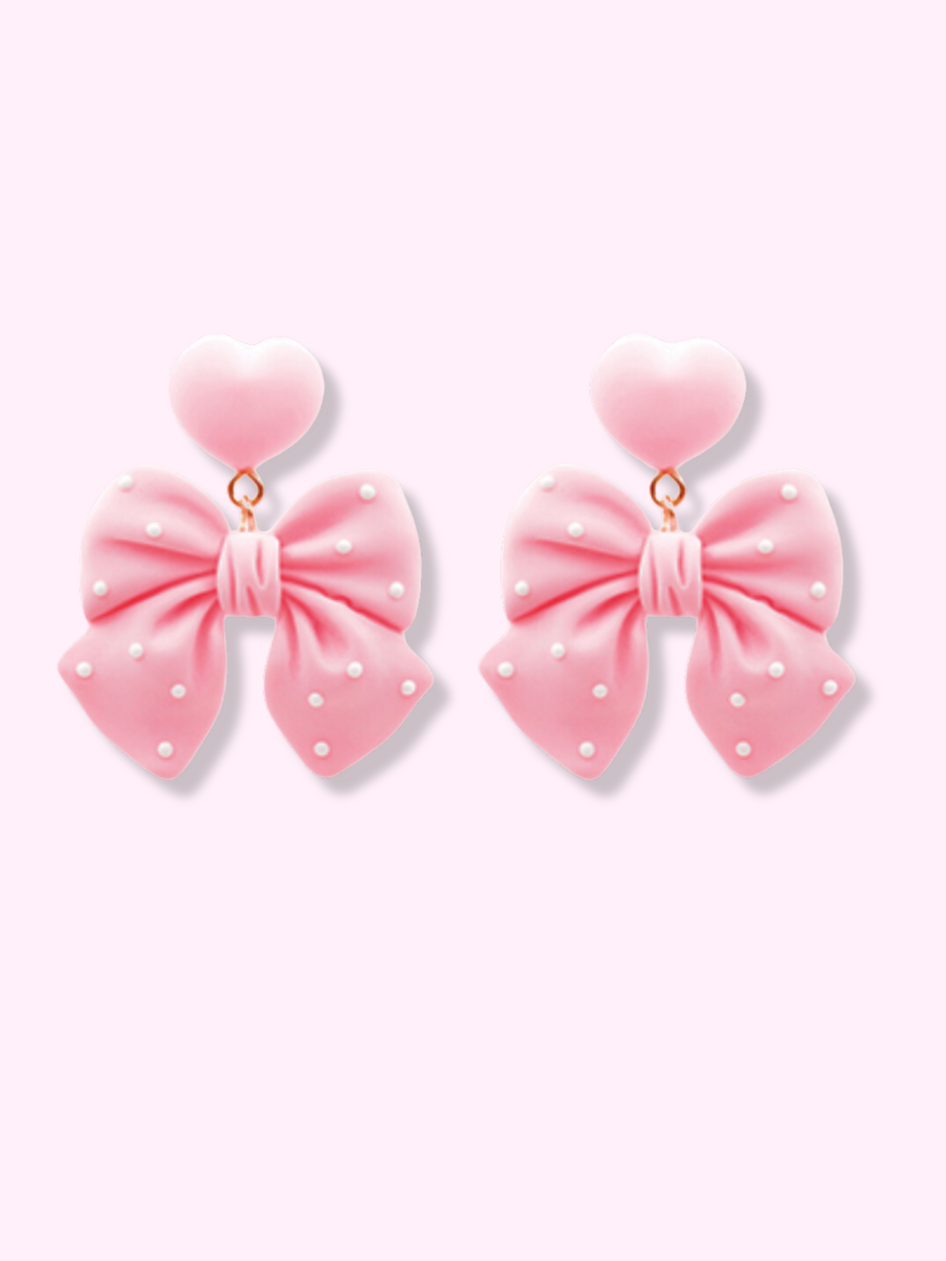 Polka Heart Bow Earrings in pink: charming bow design with white polka dots and heart accents.
