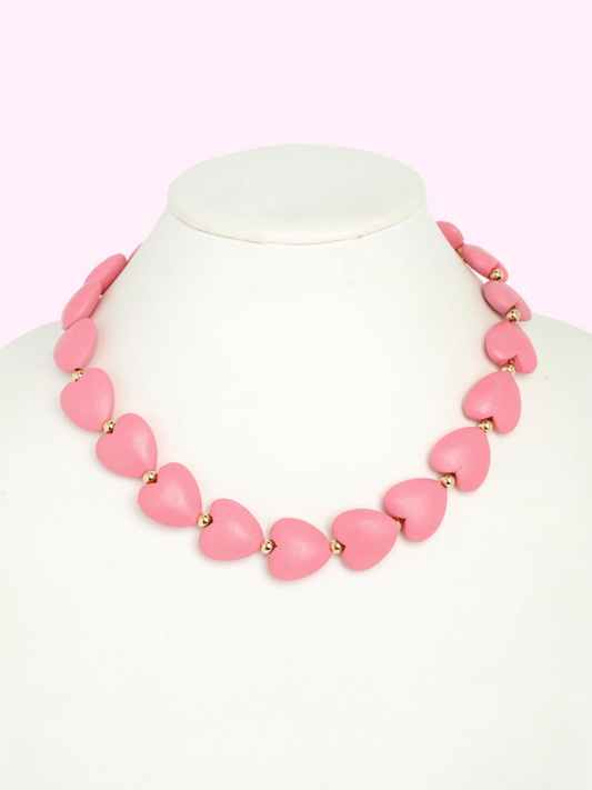 XOXO Pink heart necklace from Sassy Shortcake on a white mannequin, gold accents.
