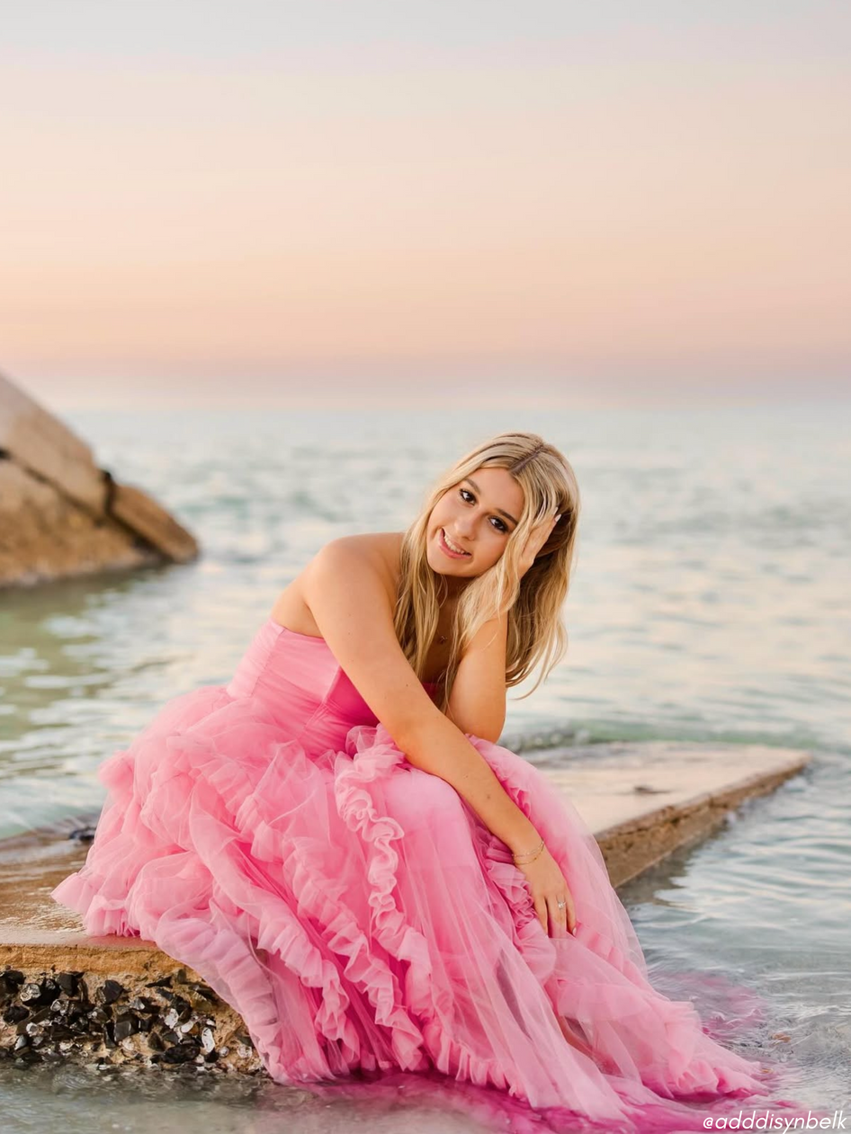 Pink tulle gown by the ocean at sunset.
