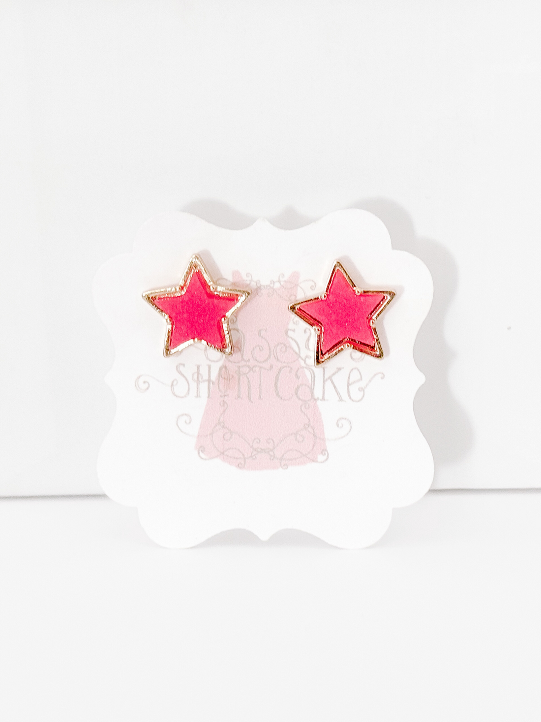 Pink star earrings with gold accents
