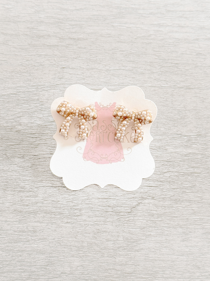 Sadie Bow pearl earrings: gold tone bow adorned with creamy white pearls.

