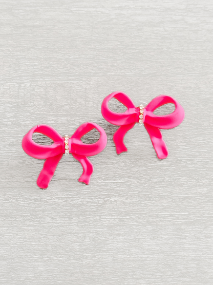 Livvy Bow Earrings: Hot pink resin bow earrings with rhinestone accents.
