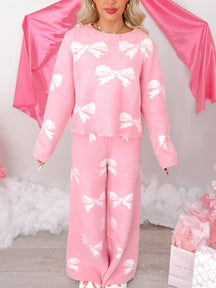 Pink fuzzy sweater and wide-leg pants set; white bow pattern.
