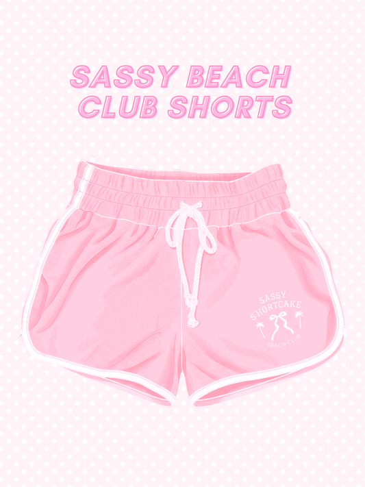 Sassy Beach Club Shorts from Sassy Shortcake - Pink shorts with 'Sassy Beach Club Shorts' text on a white background
