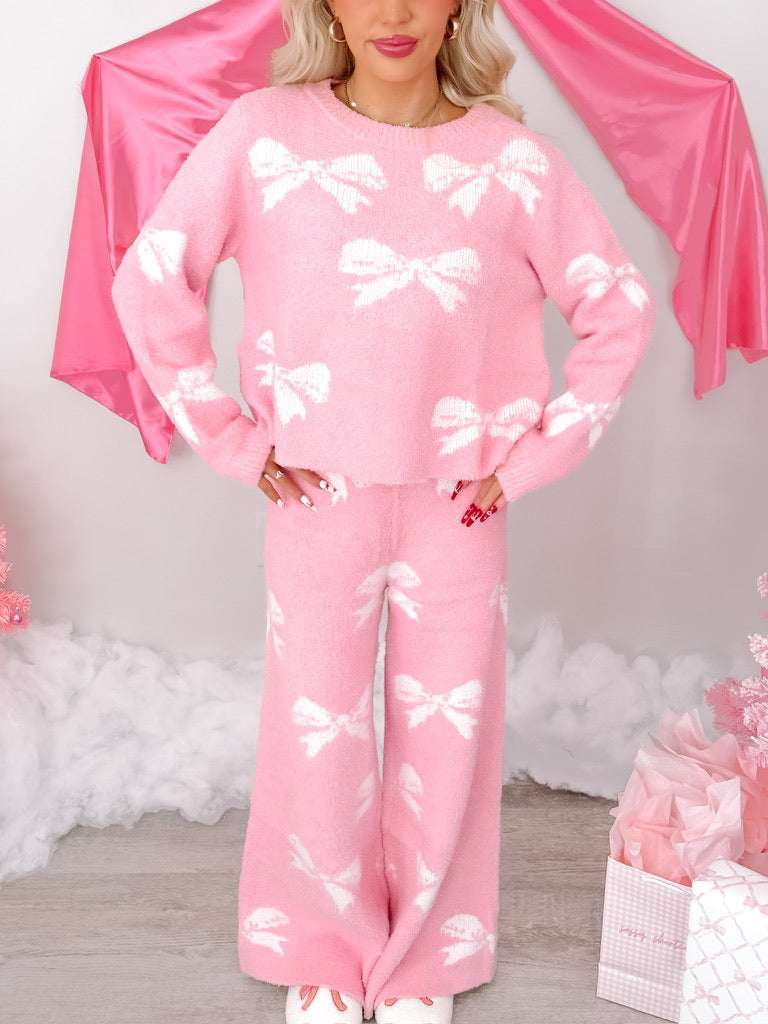 Pink fuzzy sweater and pants set; bow pattern.
