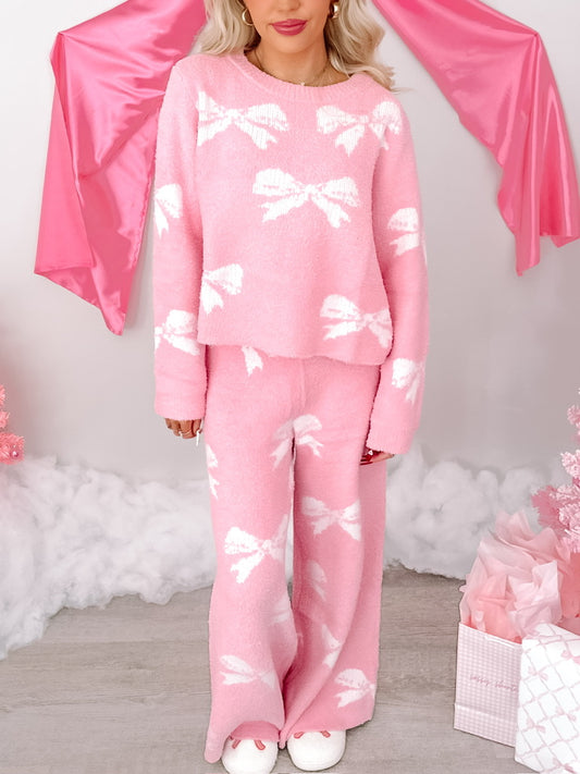 Pink fuzzy knit Better in Bows pajama set with white bow pattern; comfy lounge pants & sweater.
