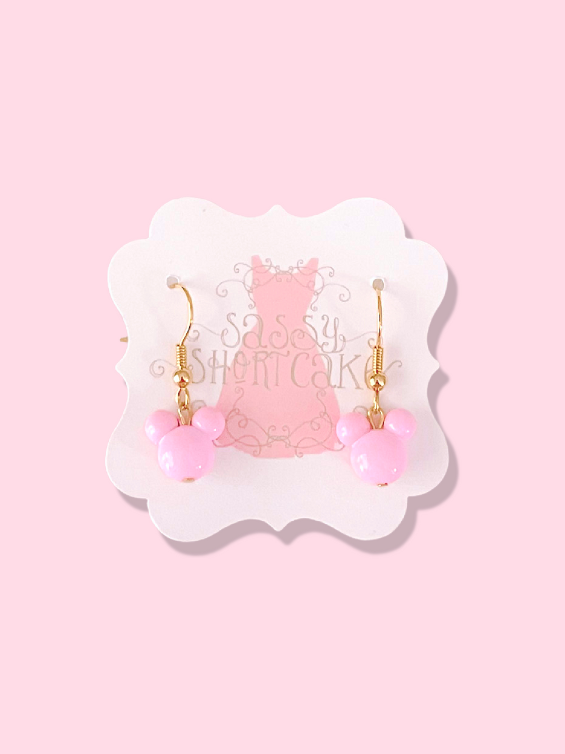 Pink Magic Mouse earrings with gold hooks, displayed on card
