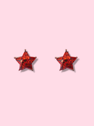 Red glitter star-shaped stud earrings on a pink background.
