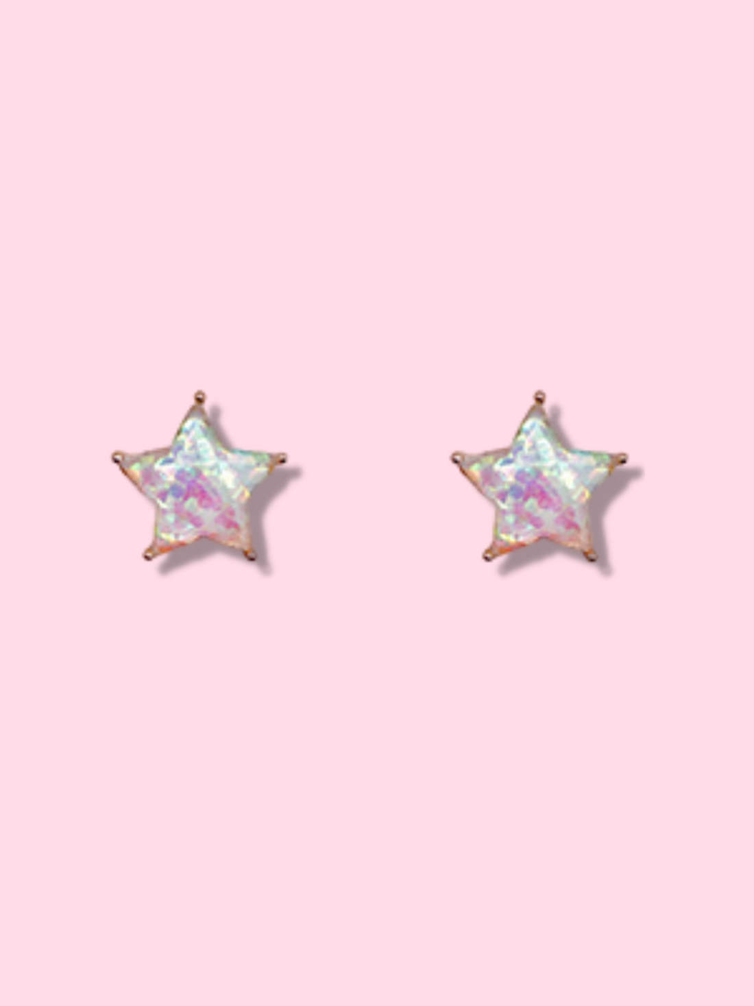 Iridescent star-shaped earrings on pink background
