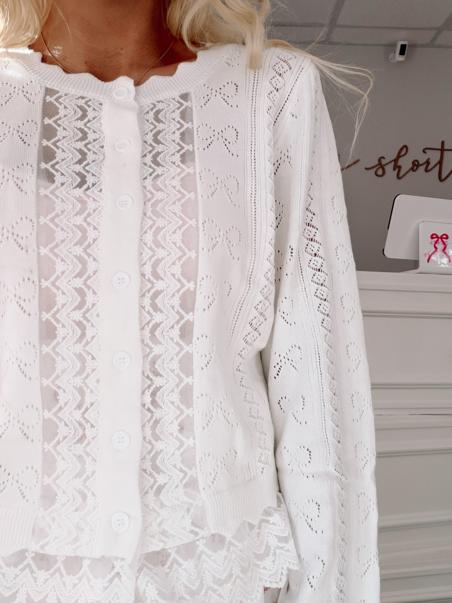 Bisous Bow Cardigan from Sassy Shortcake - White lace garment with a blurred background