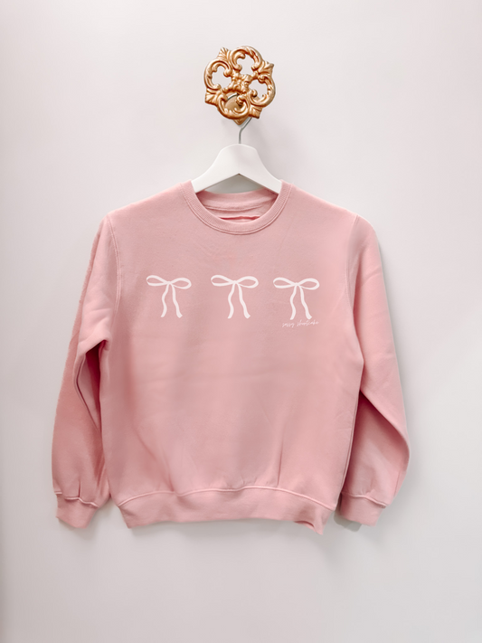 Pink Blushing Bow Kids Crewneck sweatshirt with three white bows, by Sassy Shortcake.
