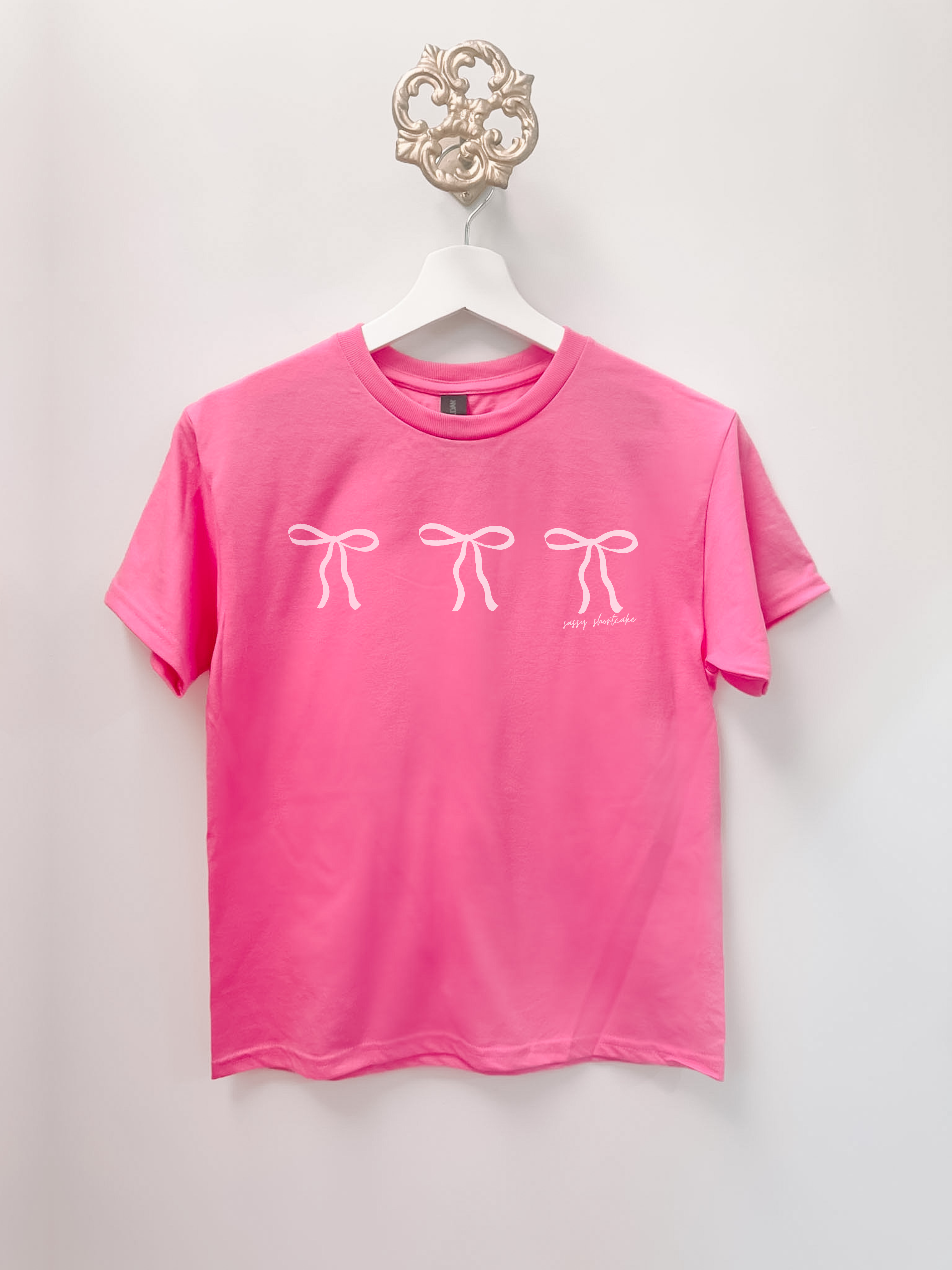 Pink Blushing Bow Kids Tee with three white bows and 