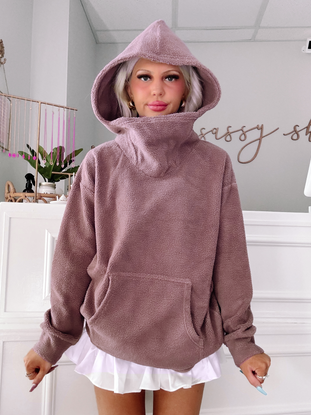 Mauve teddy pullover with a large hood, shown styled with a white ruffled skirt.
