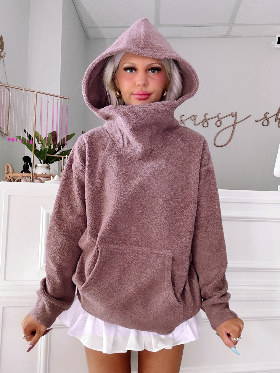 Mauve teddy pullover with a large hood, shown styled with a white ruffled skirt.
